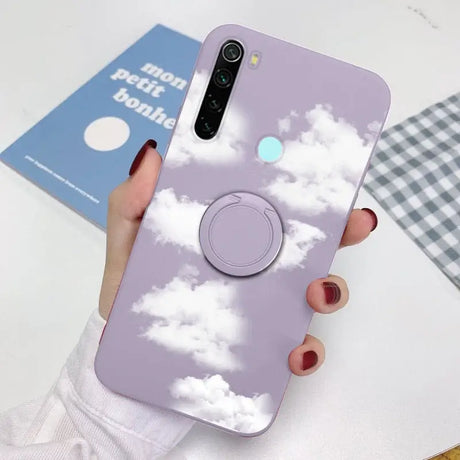 a woman holding a phone case with a cloud pattern