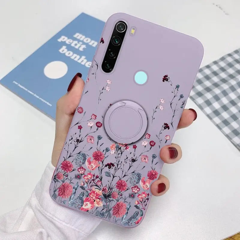 a woman holding a phone case with flowers on it