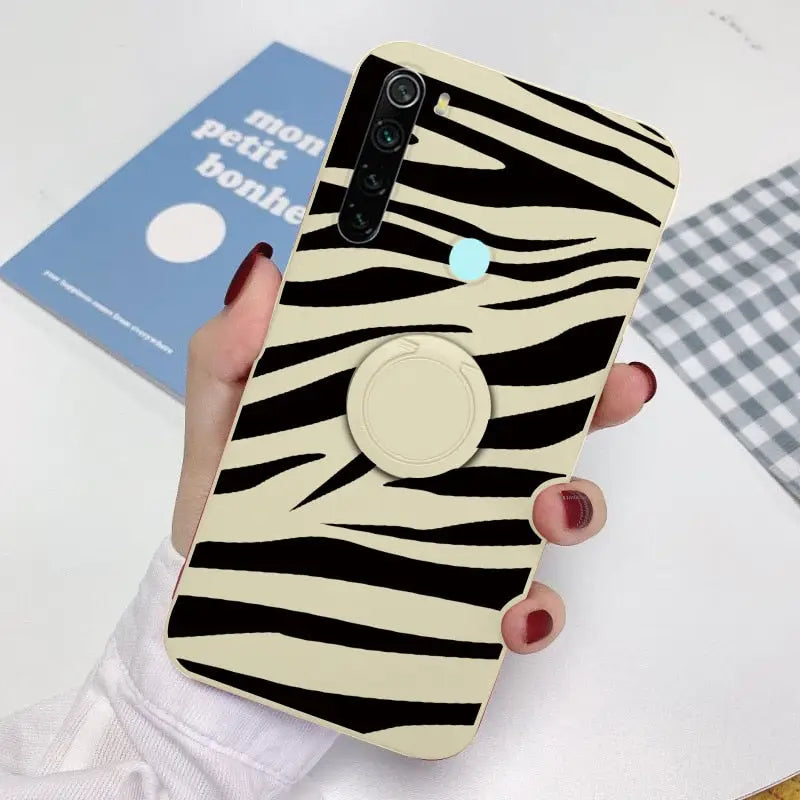 a woman holding a phone case with a zebra print