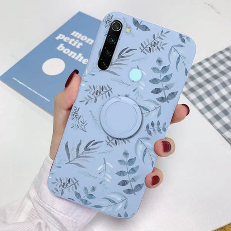 a woman holding a phone case with a blue floral pattern