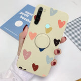 a woman holding a phone case with hearts on it