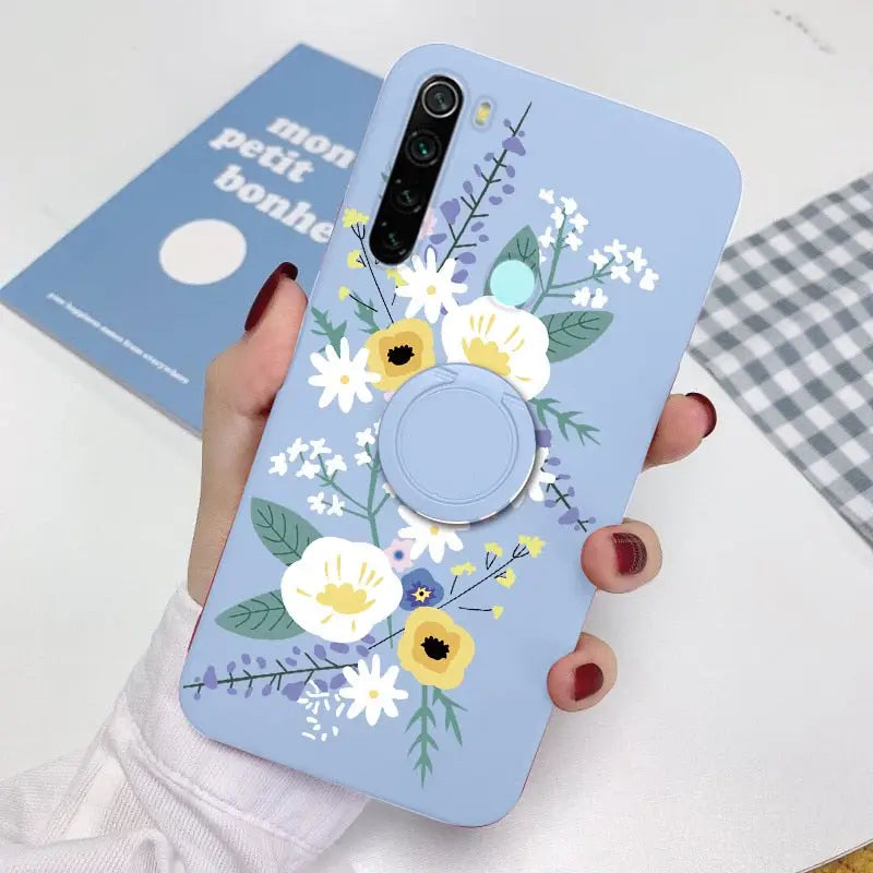 a woman holding a phone case with flowers on it