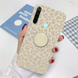 a woman holding a phone case with a leopard print