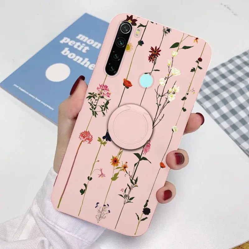 a woman holding a phone case with flowers on it