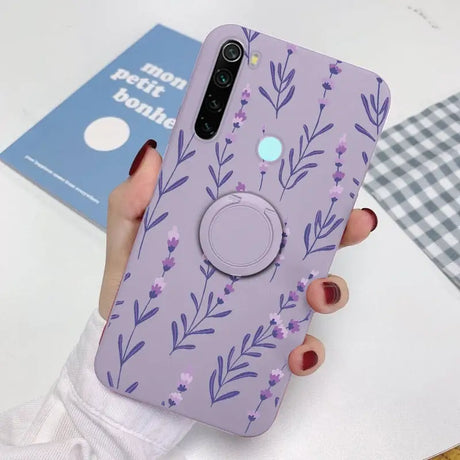 a woman holding a phone case with purple flowers on it