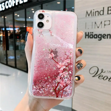 a woman holding a phone case with pink flowers on it