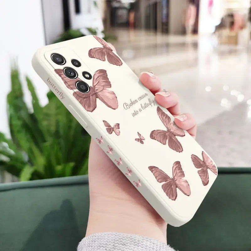 a woman holding a phone case with butterflies on it