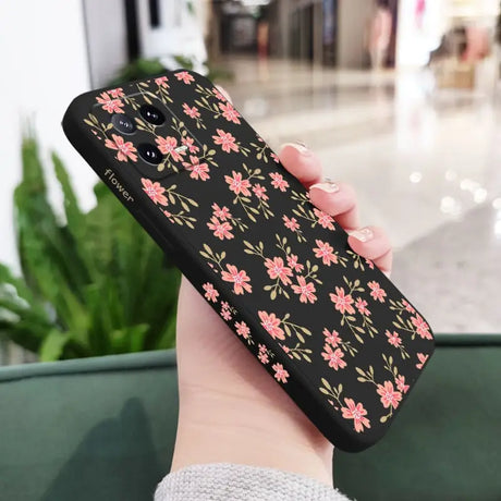 a woman holding a phone case with pink flowers on it