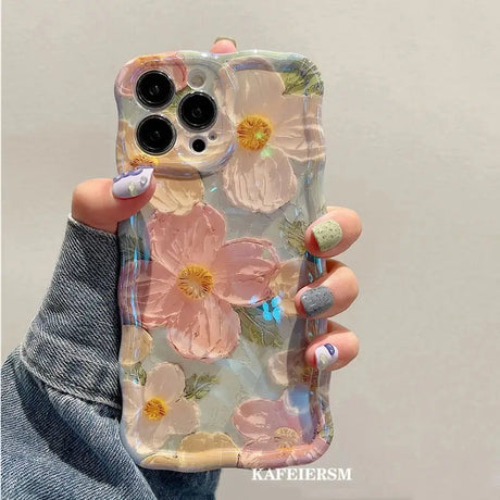 a woman holding a phone case with flowers on it