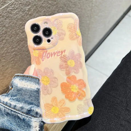 a woman holding a phone case with flowers on it