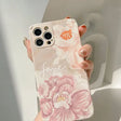 a woman holding a phone case with flowers on it