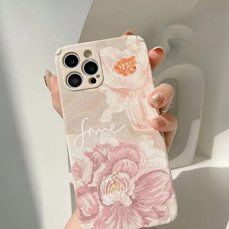 a woman holding a phone case with flowers on it