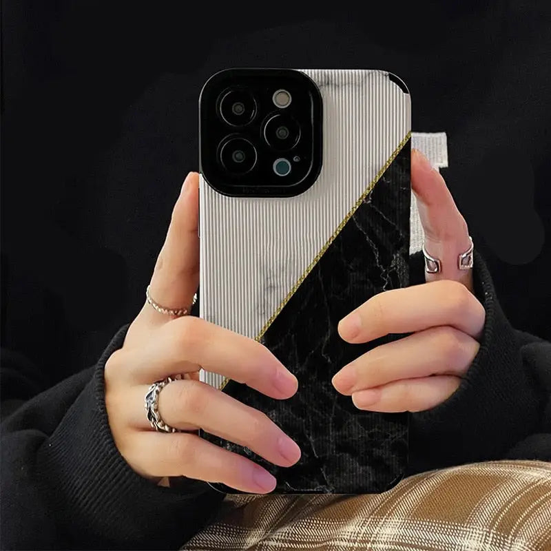 a woman holding a phone case with a black and white marble pattern
