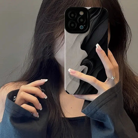 a woman holding up her phone case