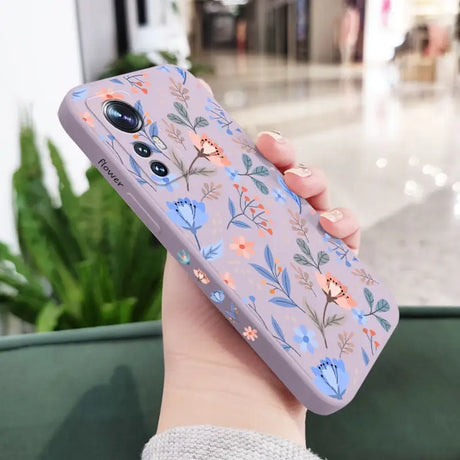 a woman holding a phone case with flowers on it