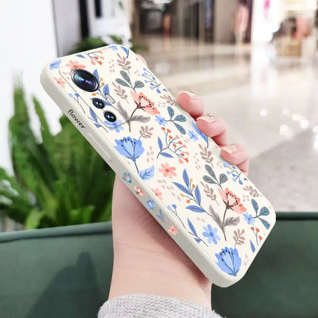 a woman holding a phone case with a floral pattern