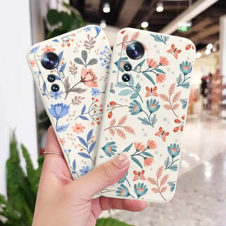 a woman holding up a phone case with flowers on it