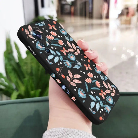 a woman holding a phone case with a floral pattern