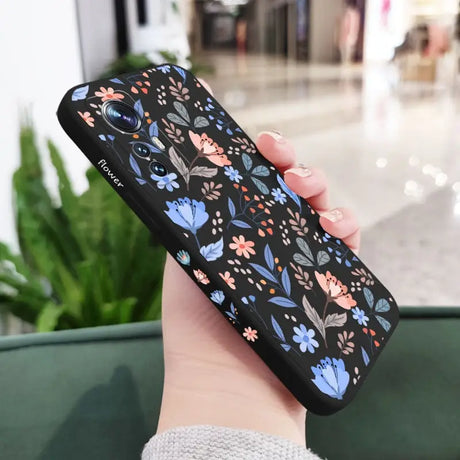 a woman holding a phone case with a floral pattern