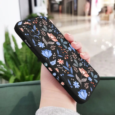 a woman holding a phone case with a floral pattern