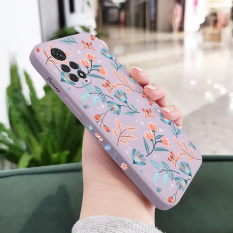 a woman holding a phone case with flowers on it