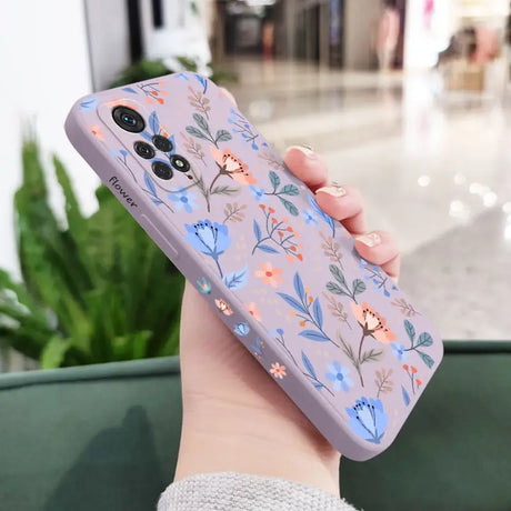 a woman holding a phone case with flowers on it