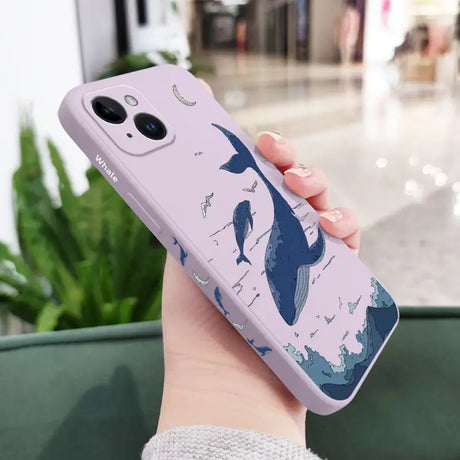 a woman holding a phone case with a whale on it