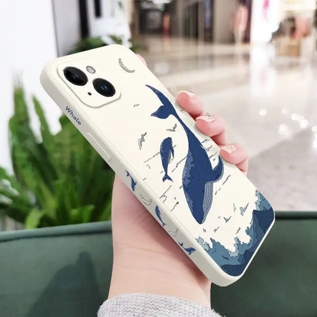 a woman holding a phone case with a whale on it