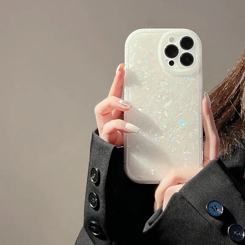 a woman holding a phone case with a white liquid