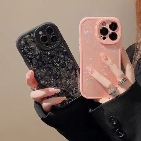 a woman holding a phone case with a black and white marble pattern
