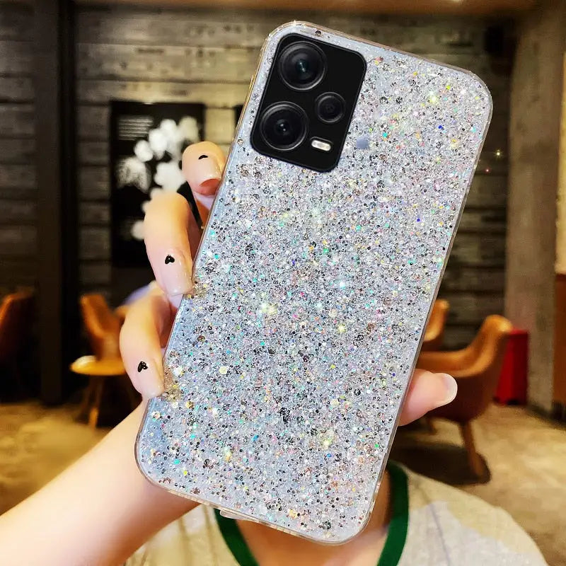 a woman holding up a phone case with a silver glitter cover