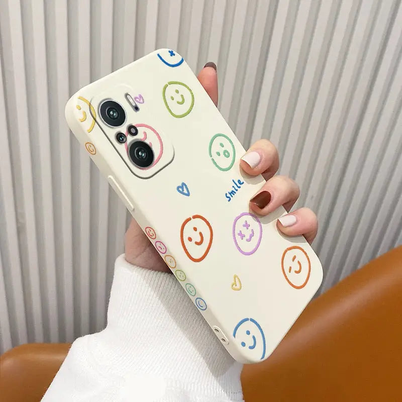 a woman holding a phone case with smiley faces on it