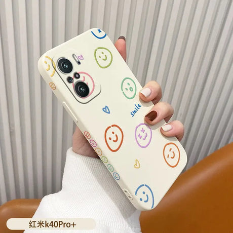 a woman holding a phone case with smiley faces on it