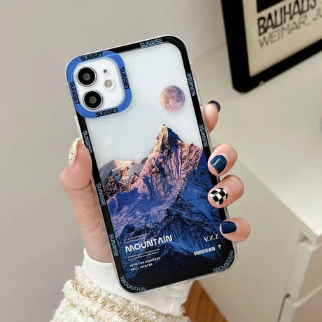 a woman holding a phone case with a mountain scene