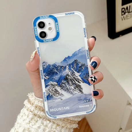 a woman holding a phone case with a mountain scene