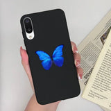 a woman holding a phone case with a blue butterfly on it