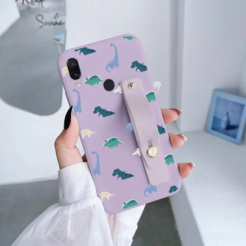 a woman holding a phone case with dinosaurs on it