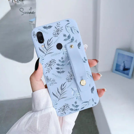 a woman holding a phone case with a floral pattern