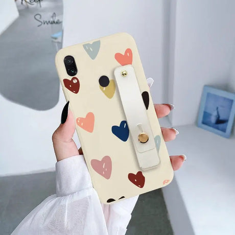 a woman holding a phone case with hearts on it