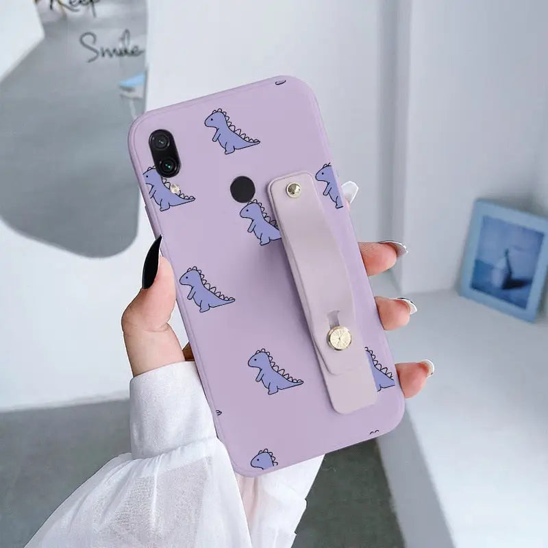 a woman holding a phone case with a unicorn pattern