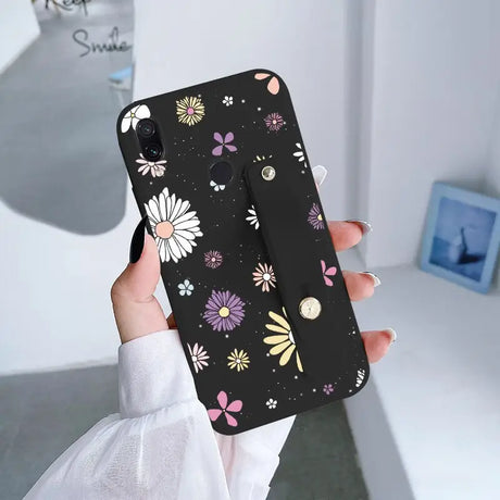 a woman holding a phone case with flowers on it