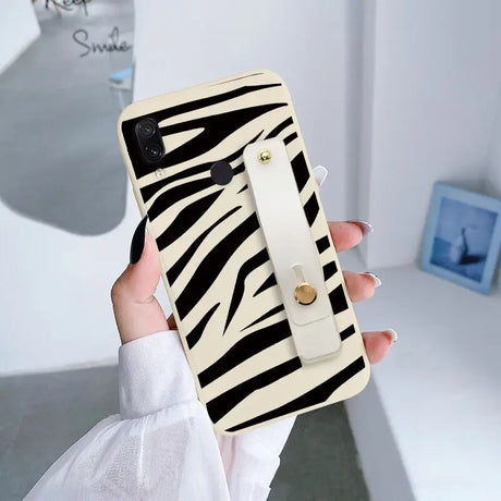 a woman holding a phone case with zebra print