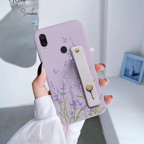 a woman holding a phone case with a purple flower design