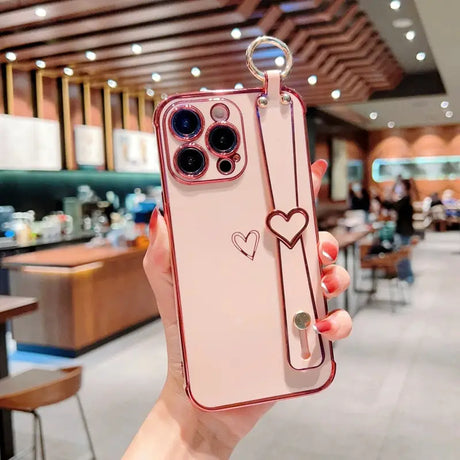 a woman holding up a phone case with a heart