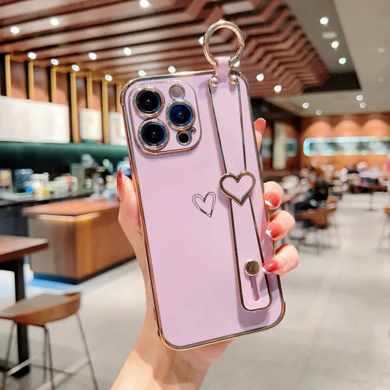 a woman holding a pink iphone case with a heart shaped key