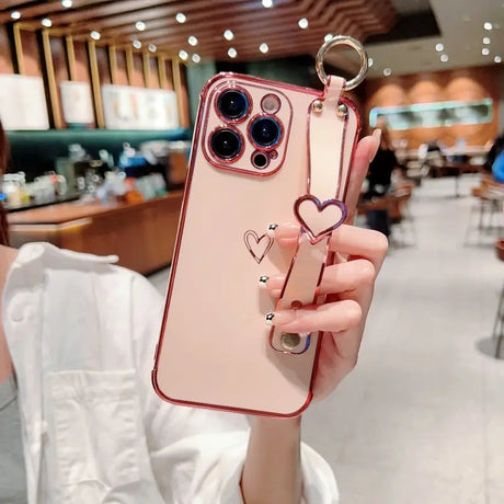 a woman holding a phone case with a heart shaped ring