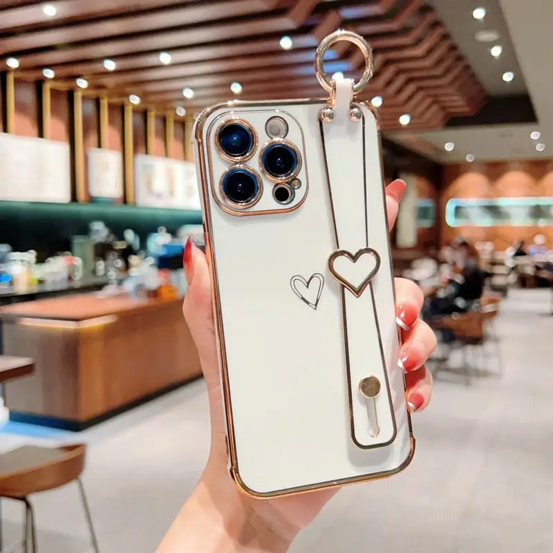 a woman holding up a phone case with a heart