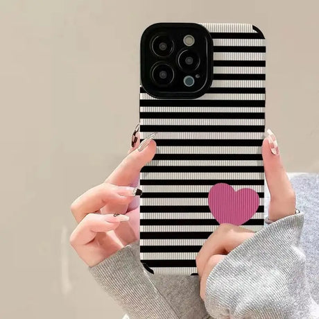 a woman holding a phone case with a heart on it