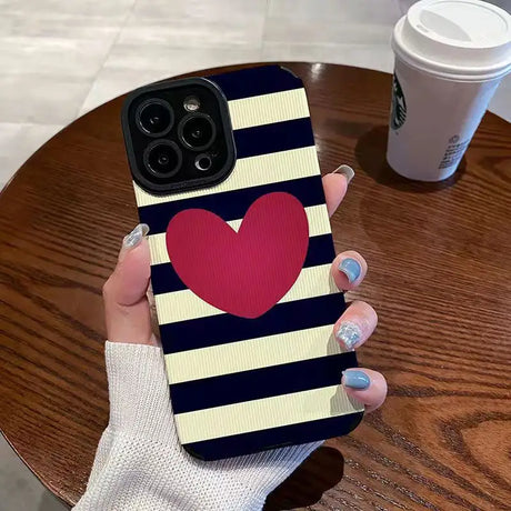 a woman holding a phone case with a heart on it