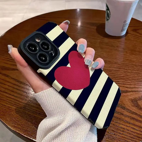 a woman holding a phone case with a heart on it